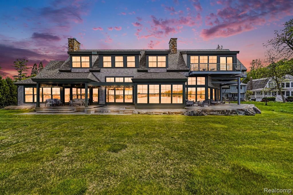 Lakeside view of the home at twilight across the back lawn