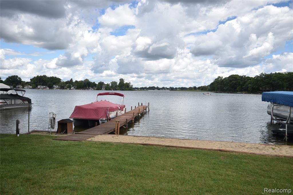 Private dock with a boat lift and a lawn running to the water